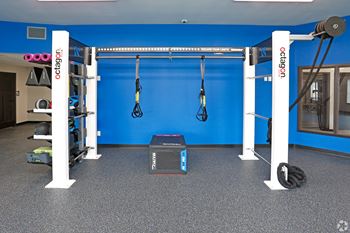 A home gym with a blue wall and a black and white machine in the middle of the
